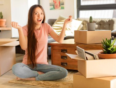 Güzel bir kadın mutlu, heyecanlı, şaşırmış ya da şaşırmış hissediyor, gülümsüyor ve hayret verici bir şeye şaşırıyor.