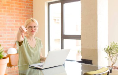 Evde dizüstü bilgisayar kullanan genç ve güzel bir kız.