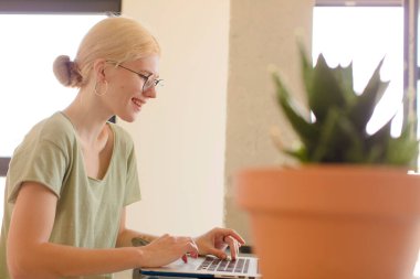 Evde dizüstü bilgisayar kullanan genç ve güzel bir kız.