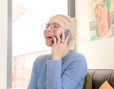 Evdeki genç ve güzel kız telefon kullanıyor.