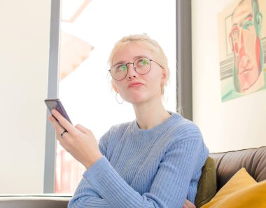 Evdeki genç ve güzel kız telefon kullanıyor.