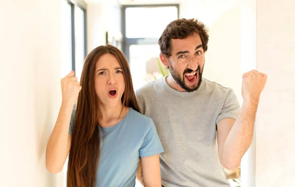 Young Couple Shouting Aggressively Angry Expression Fists Clenched Celebrating Success — Stock Photo, Image