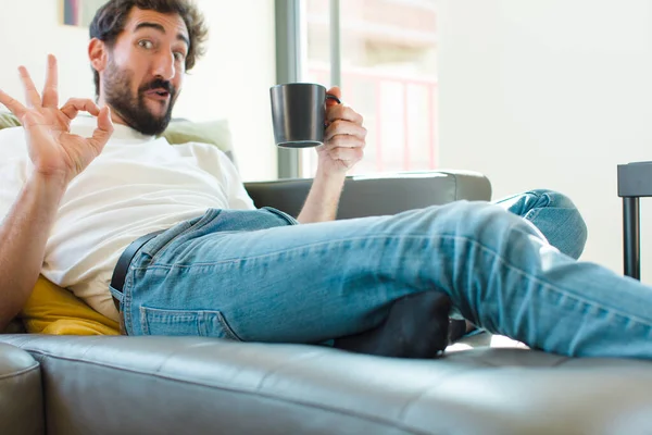 Jovem Barbudo Homem Descansando Sofá Com Uma Caneca Café — Fotografia de Stock