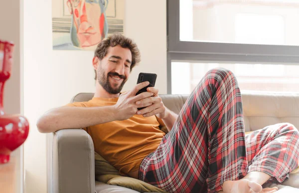 Junger Bärtiger Mann Auf Einer Couch Mit Smartphone — Stockfoto