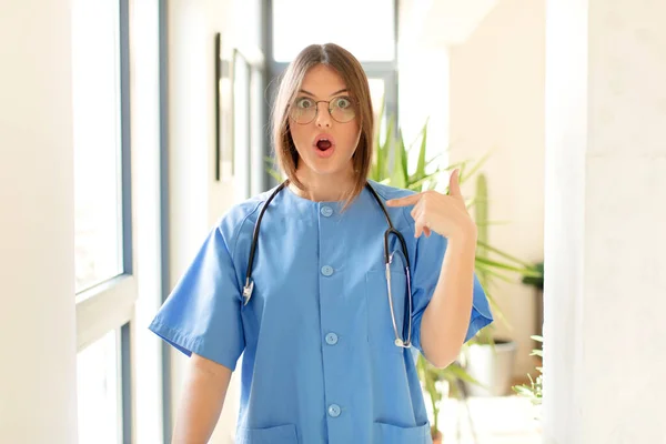 Pretty Nurse Looking Shocked Surprised Mouth Wide Open Pointing Self — Stock Photo, Image