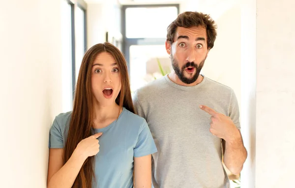 Jeune Couple Regardant Choqué Surpris Avec Bouche Grande Ouverte Pointant — Photo