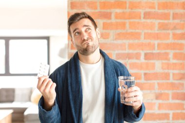 Su ve haplı genç yakışıklı adam.