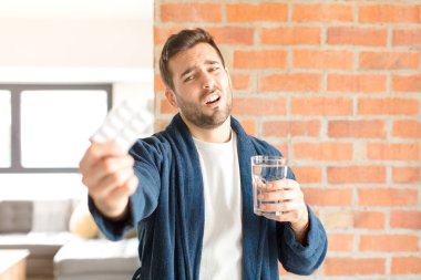 Su ve haplı genç yakışıklı adam.