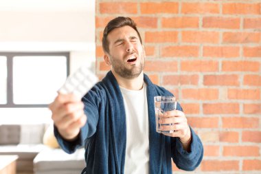 Su ve haplı genç yakışıklı adam.