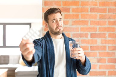 Su ve haplı genç yakışıklı adam.