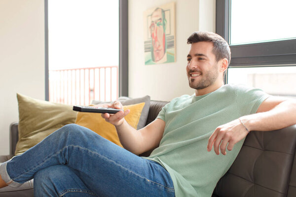 young handsome man choosing a television channel