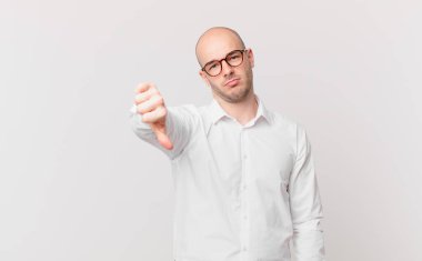 Kel bir adam kızgın, sinirli, hayal kırıklığına uğramış ya da canı sıkkın, ciddi bir bakışla başparmağını kaldırıyor.