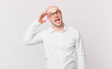 Kel adam mutlu, şaşkın ve şaşırmış görünüyor, gülümsüyor ve inanılmaz ve inanılmaz iyi haberleri fark ediyor.