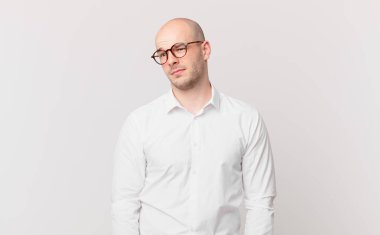 Kel bir adam üzgün, üzgün ya da kızgın. Olumsuz bir tavır sergiliyor, anlaşmazlık içinde kaşlarını çatıyor.