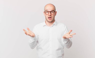 Kel adam son derece şok olmuş ve şaşırmış, endişeli ve panik içinde, stresli ve dehşete düşmüş bir bakışla