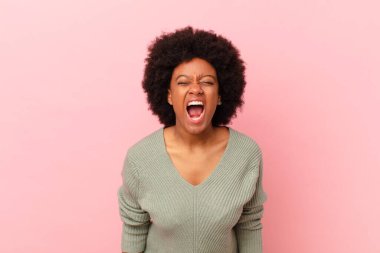 Afro siyah kadın agresif bir şekilde bağırıyor, kızgın, sinirli, öfkeli ya da sinirli görünüyor, hayır diye bağırıyor.