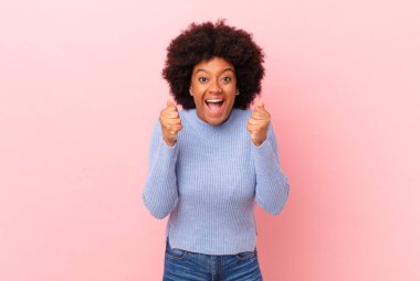 Afro siyah kadın şaşkın, heyecanlı ve mutlu hissediyor, gülüyor ve başarıyı kutluyor,!