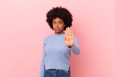 Afro siyah kadın ciddi, sert, hoşnutsuz ve kızgın görünüyor.