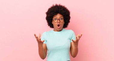 Afro siyahi kadın ağzı açık ve şaşırmış, şok olmuş ve hayrete düşmüş inanılmaz bir sürprizle