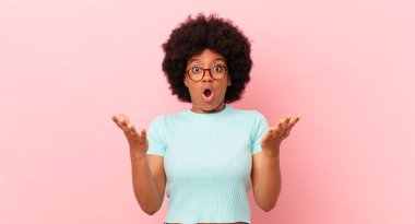 Afro siyah kadın aşırı derecede şok olmuş ve şaşırmış, endişeli ve paniklemiş hissediyor, stresli ve dehşete kapılmış bir bakışla