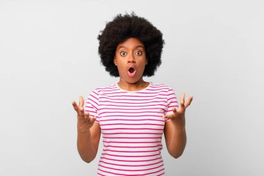 Afro siyahi kadın ağzı açık ve şaşırmış, şok olmuş ve hayrete düşmüş inanılmaz bir sürprizle