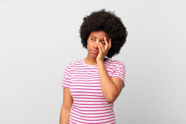 Afro siyah kadın sıkılmış, hayal kırıklığına uğramış ve uykulu. Yorucu, sıkıcı ve can sıkıcı bir işin ardından, el ele tutuşarak.