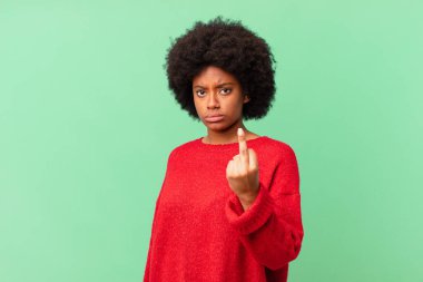Afro siyah kadın kızgın, sinirli, asi ve agresif hissediyor, orta parmağını sallıyor, karşı koyuyor.