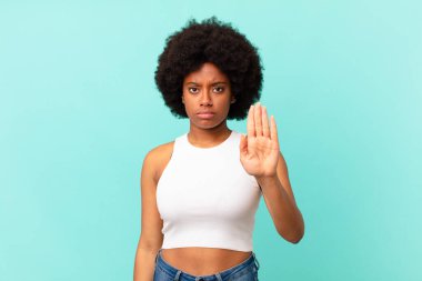 Afro siyah kadın ciddi, sert, hoşnutsuz ve kızgın görünüyor.