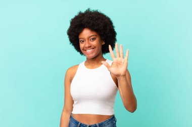 Afro siyah kadın gülümsüyor ve arkadaş canlısı görünüyor, 5 ya da 5 numarayı gösteriyor, eli önde, geriye doğru sayıyor