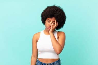 Afro siyah kadın sıkılmış, hayal kırıklığına uğramış ve uykulu. Yorucu, sıkıcı ve can sıkıcı bir işin ardından, el ele tutuşarak.