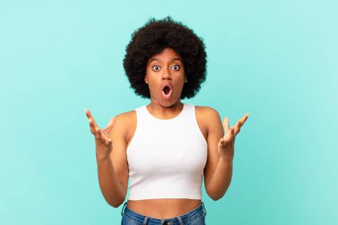 Afro siyah kadın aşırı derecede şok olmuş ve şaşırmış, endişeli ve paniklemiş hissediyor, stresli ve dehşete kapılmış bir bakışla