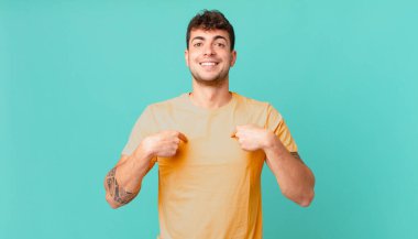 Yakışıklı adam mutlu, şaşkın ve gururlu, heyecanlı, şaşkın bakışlarla kendini işaret ediyor.