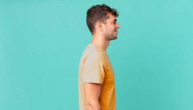 Profil görünümünde yakışıklı bir adam uzayı kopyalamaya çalışıyor, düşünüyor, hayal ediyor ya da hayal kuruyor.