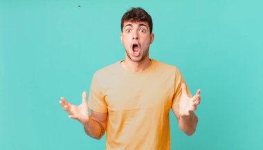 Yakışıklı, ağzı açık ve şaşırmış, şok olmuş ve hayrete düşmüş bir adam.