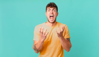 Yakışıklı adam umutsuz ve sinirli görünüyor, stresli, mutsuz ve sinirli, bağırıyor ve çığlık atıyor.