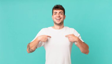 Yakışıklı adam mutlu, şaşkın ve gururlu, heyecanlı, şaşkın bakışlarla kendini işaret ediyor.