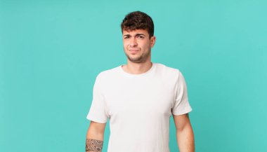 Yakışıklı bir adam üzgün, üzgün ya da kızgın. Olumsuz bir tavır sergiliyor, anlaşmazlık içinde kaşlarını çatıyor.