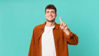 Yakışıklı bir adam gülümsüyor ve arkadaş canlısı görünüyor. Bir numara ya da ilk eli önde, geriye doğru sayıyor.