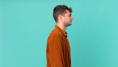 Profil görünümünde yakışıklı bir adam uzayı kopyalamaya çalışıyor, düşünüyor, hayal ediyor ya da hayal kuruyor.