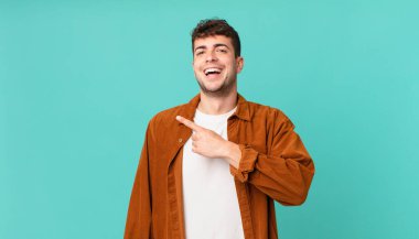 Yakışıklı adam heyecanlı ve şaşırmış görünüyor. Yana ve yukarı doğru uzayı gösteriyor.