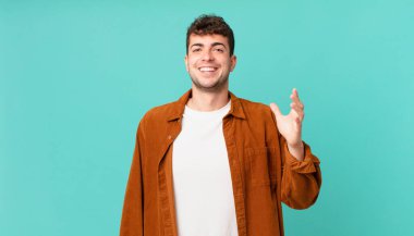 Yakışıklı adam kendini mutlu, şaşırmış ve neşeli hissediyor. Pozitif bir tavırla gülümsüyor. Bir çözüm ya da fikir buluyor.