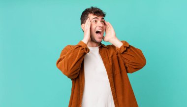 Yakışıklı adam mutlu, heyecanlı ve şaşırmış hissediyor, iki eli yüzü yana bakıyor.