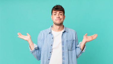 Yakışıklı adam şaşkın ve şaşkın, şüpheci, farklı seçenekleri tartıyor ya da komik bir ifadeyle seçiyor.