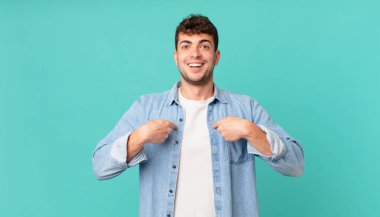 Yakışıklı adam mutlu, şaşkın ve gururlu, heyecanlı, şaşkın bakışlarla kendini işaret ediyor.