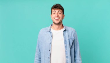 Yakışıklı adam mutlu ve hoş bir şekilde şaşırmış görünüyor. Büyülenmiş ve şok olmuş bir ifadeyle heyecanlanıyor.