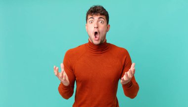 Yakışıklı, ağzı açık ve şaşırmış, şok olmuş ve hayrete düşmüş bir adam.