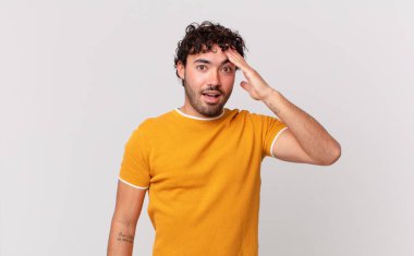 İspanyol yakışıklı adam mutlu, şaşkın ve şaşırmış görünüyor, gülümsüyor ve inanılmaz ve inanılmaz iyi haberleri fark ediyor.