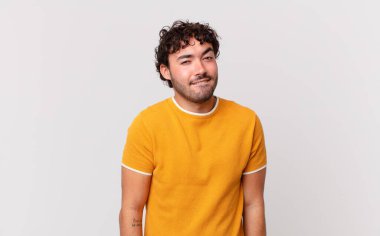 İspanyol yakışıklı adam şaşkın ve şaşkın görünüyor. Sinirli bir hareketle dudağını ısırıyor. Sorunun cevabını bilmiyor.