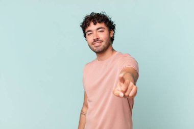 İspanyol yakışıklı bir adam kameraya bakıyor. Tatmin olmuş, kendine güvenen, dost canlısı bir gülümsemeyle, seni seçiyor.