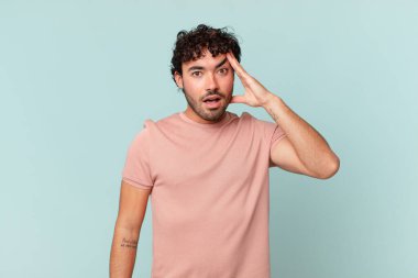 İspanyol yakışıklı adam mutlu, şaşkın ve şaşırmış görünüyor, gülümsüyor ve inanılmaz ve inanılmaz iyi haberleri fark ediyor.